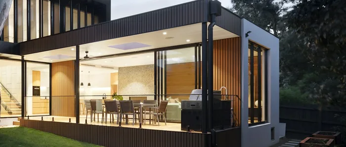 Covered terrace with a dining table and a built-in cooking unit.
